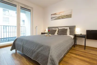 a bedroom with a large bed and a television at Zabłocie Charming Studio A in Kraków