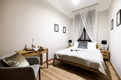 a bedroom with a bed and a chair and a window at Old Town AC apartments Main Raiway Station in Kraków
