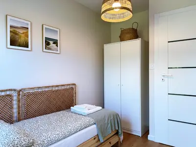 a bedroom with a bed and a white cabinet at Wieli Apartment in Wieliczka