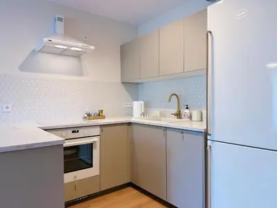 a kitchen with white cabinets and a refrigerator at Wieli Apartment in Wieliczka
