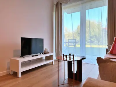 a living room with a flat screen tv on a white entertainment center at Wieli Apartment in Wieliczka