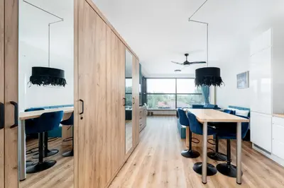 a dining room with a table and blue chairs at Wiślane Tarasy 2 0 Blue Studio by BookingHost in Kraków