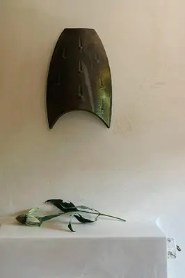 a light on a wall with a flower on a table at hOMM domek nad jeziorem in Stryszów