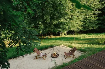 two chairs and a fire pit in a yard at hOMM domek nad jeziorem in Stryszów