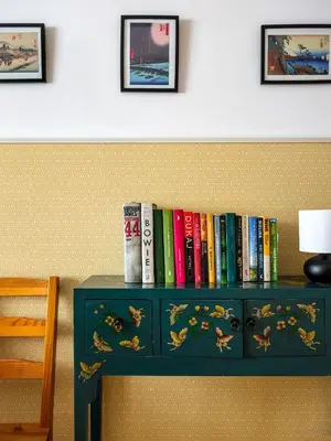 a shelf with books on top of a table at Rewers apartment - Świętokrzyska St in Kraków