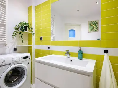 a bathroom with a washing machine and a sink at Rewers apartment - Świętokrzyska St in Kraków
