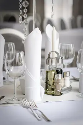 a white table with wine glasses and silverware at Pałac Lacon in Kazimierza Wielka