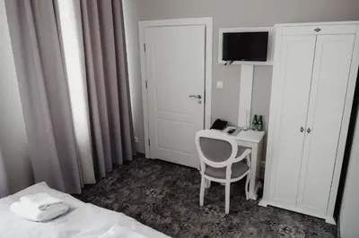 a bedroom with a bed and a desk with a television at Pałac Lacon in Kazimierza Wielka