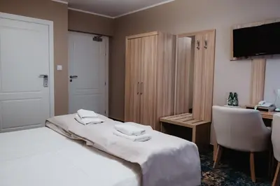 a hotel room with a bed and a desk and a television at Pałac Lacon in Kazimierza Wielka