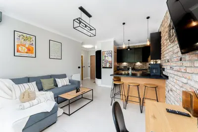 a living room with a blue couch and a kitchen at Malila Premium Apartments Cracow Tauron Arena Lema 15 in Kraków