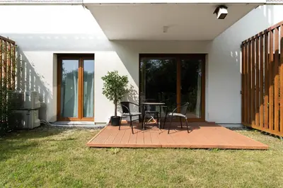 a patio with a table and chairs in a yard at Malila Premium Apartments Cracow Tauron Arena Lema 15 in Kraków