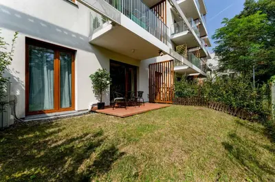 a house with a lawn in front of a building at Malila Premium Apartments Cracow Tauron Arena Lema 15 in Kraków