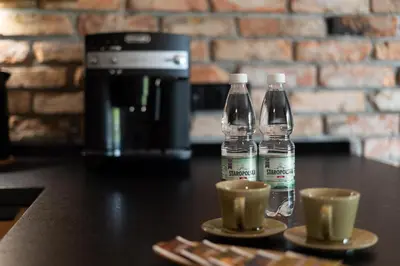 two bottles of water sitting on a table with cups at Malila Premium Apartments Cracow Tauron Arena Lema 15 in Kraków