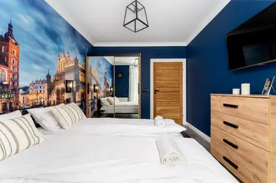 a bedroom with a large white bed with a painting on the wall at Malila Premium Apartments Cracow Tauron Arena Lema 15 in Kraków