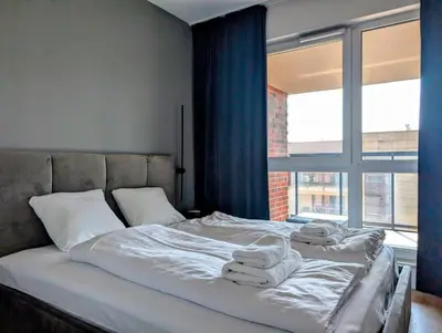 a bed with towels on it in a room with a window at Riverside Base Zabłocie in Kraków