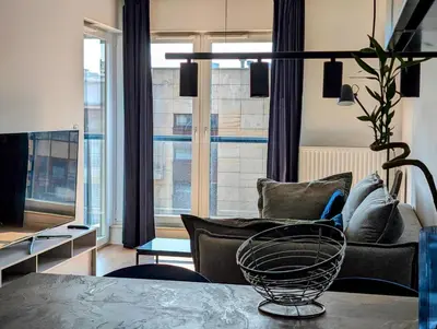 a living room with a couch and a table at Riverside Base Zabłocie in Kraków
