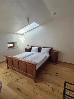 a bedroom with a large wooden bed with a skylight at Aparthotel Miodowa 25 in Kraków