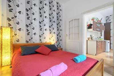 a bedroom with a red bed with two pillows on it at City Fever Apartment Kazimierz, WiFi in Kraków