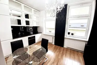 a dining room with a glass table and two windows at Old Town - Traugutta Street flat 9 in Kraków