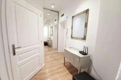 a hallway with a door and a dresser and a mirror at Old Town - Traugutta Street flat 9 in Kraków