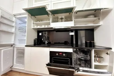 a kitchen with white cabinets and a stove top oven at Old Town - Traugutta Street flat 9 in Kraków