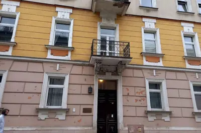 a yellow building with a black door and a balcony at Old Town - Traugutta Street flat 9 in Kraków