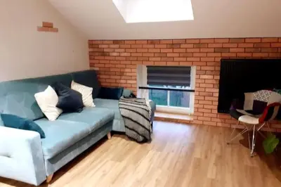 a living room with a blue couch and a brick wall at Loft Apartment Old Town - G47 in Kraków