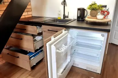 an open refrigerator in a kitchen next to a sink at Loft Apartment Old Town - G47 in Kraków
