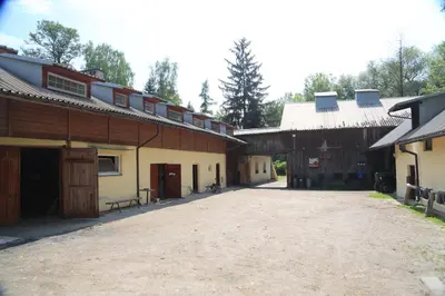 a dirt road between two buildings with a barn at Gospodarstwo Agroturystyczne Stary Młyn Wilczkowice in Michałowice
