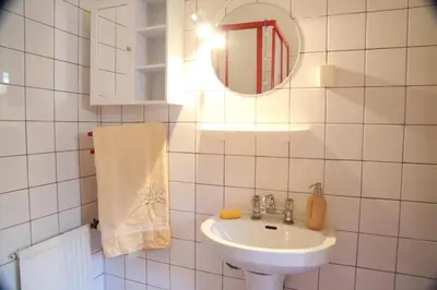 a white bathroom with a sink and a mirror at Gospodarstwo Agroturystyczne Stary Młyn Wilczkowice in Michałowice