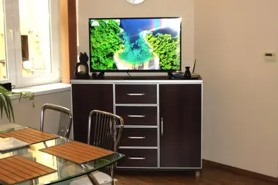 a flat screen tv sitting on top of a entertainment center at Caffe Latte, City Center Apartment in Kraków
