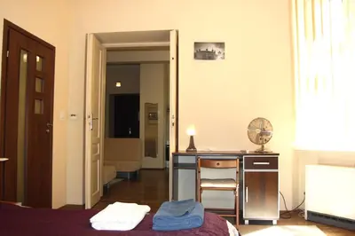 a room with a bed and a desk with a fan at Caffe Latte, City Center Apartment in Kraków