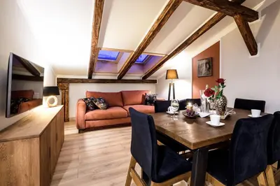 a living room with a table and a couch at Air-conditioned attic apartment Old Town Main Railway Station in Kraków