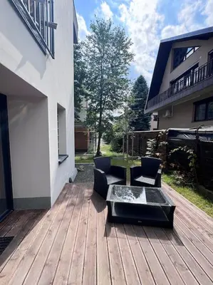 a wooden deck with a table and chairs on a house at Apartamenty na Wodzienowskiego in Kraków