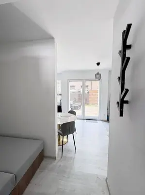 a white living room with a table and a couch at Apartamenty na Wodzienowskiego in Kraków