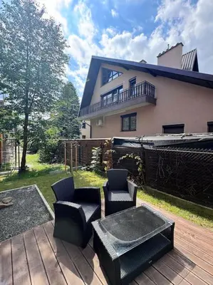 a patio with chairs and a table and a house at Apartamenty na Wodzienowskiego in Kraków