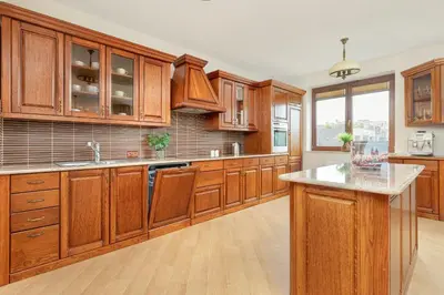 a large kitchen with wooden cabinets and a counter top at Przytulny Apartament z Klimatyzacją i Parkingiem by Noclegi Renters in Kraków