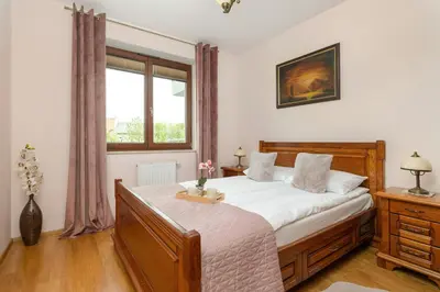 a bedroom with a large bed and a window at Przytulny Apartament z Klimatyzacją i Parkingiem by Noclegi Renters in Kraków