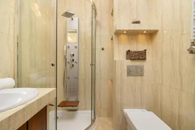 a bathroom with a shower and a toilet and a sink at Przytulny Apartament z Klimatyzacją i Parkingiem by Noclegi Renters in Kraków