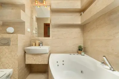 a bathroom with a tub and a sink and a mirror at Przytulny Apartament z Klimatyzacją i Parkingiem by Noclegi Renters in Kraków