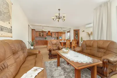 a living room with leather furniture and a table at Przytulny Apartament z Klimatyzacją i Parkingiem by Noclegi Renters in Kraków