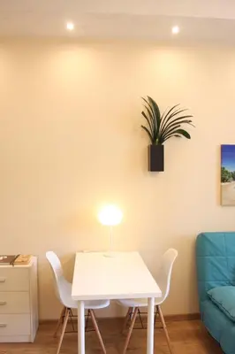 a table and chairs in a room with a plant on the wall at Blue Traveler AC Apartment in Kazimierz in Kraków