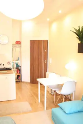 a living room with a table and chairs and a kitchen at Blue Traveler AC Apartment in Kazimierz in Kraków