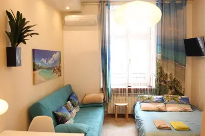 a living room with a blue couch and a window at Blue Traveler AC Apartment in Kazimierz in Kraków