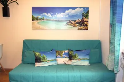 a blue couch in a room with a painting on the wall at Blue Traveler AC Apartment in Kazimierz in Kraków