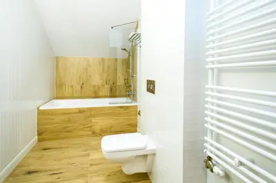 a white bathroom with a toilet and a shower at Hotel nad Rabą - Bochnia in Bochnia