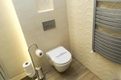 a bathroom with a toilet and a toilet paper dispenser at Hotel nad Rabą - Bochnia in Bochnia