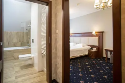 a hotel room with a bed and a bathroom at Hotel nad Rabą - Bochnia in Bochnia