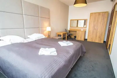 a bedroom with a large bed with towels on it at Hotel nad Rabą - Bochnia in Bochnia