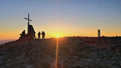 a group of people standing on top of a mountain at sunset at Willa Babia Góra in Zawoja